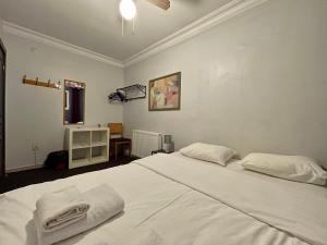 a bedroom with a large white bed with towels on it at Hush Hostel Lounge in Istanbul