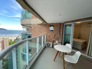 a balcony with a table and chairs and the ocean at Estanconfor Santos com Vista Mar 7 AC Garagem alto 17º andar in Santos