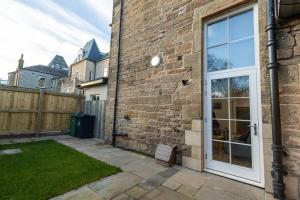 a brick building with a door and a yard at New 3-Bedroom Apartment Close to City Centre in Edinburgh