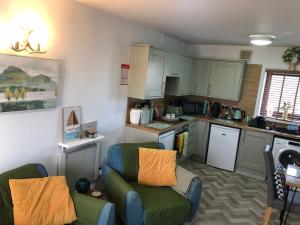 una piccola cucina con divano e sedie in camera di Dove cottage ad Allonby