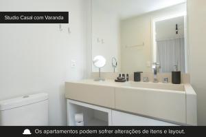 a white bathroom with a sink and a mirror at Charlie Itaim in São Paulo