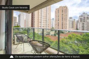 a balcony with two chairs and a view of a city at Charlie Itaim in Sao Paulo