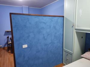 une porte bleue au milieu d'une pièce dans l'établissement Affittacamera Mauro vasto, à Vasto
