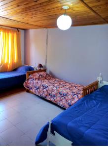 una camera con 2 letti e un soffitto in legno di Hermosa casa de vacaciones en Mendoza a Guaymallén