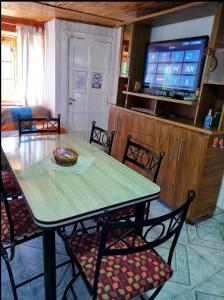 een eettafel met stoelen en een televisie bij Hermosa casa de vacaciones en Mendoza in Guaymallen