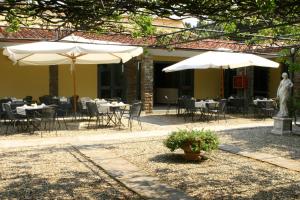 a patio area with tables and umbrellas at Hotel Villa Dei Bosconi in Fiesole
