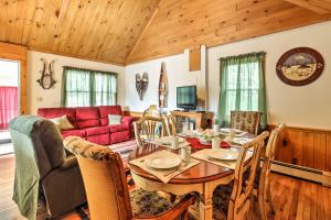 sala de estar con mesa y sofá rojo en North Creek Cottage in the Adirondacks with Fire Pit en North Creek