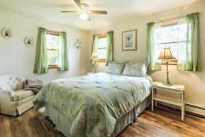 a bedroom with a bed and a chair and windows at North Creek Cottage in the Adirondacks with Fire Pit in North Creek