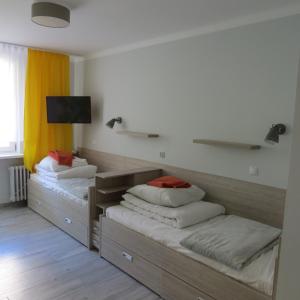 2 Betten mit Kissen auf einem Zimmer in der Unterkunft SP ZOZ Sanatorium Uzdrowiskowe MSWiA w Krynicy-Zdroju in Krynica-Zdrój