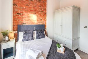 a bedroom with a bed and a brick wall at Luxurious City Centre Lace Market Apartment in Nottingham