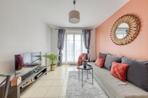 ein Wohnzimmer mit Sofa und Fernseher in der Unterkunft La Gare, Disneyland Paris terrasse parking gratuit in Bussy-Saint-Georges