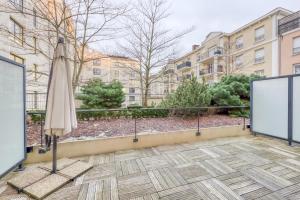 eine Terrasse mit einem Sonnenschirm und einem geschlossenen Sonnenschirm in der Unterkunft La Gare, Disneyland Paris terrasse parking gratuit in Bussy-Saint-Georges