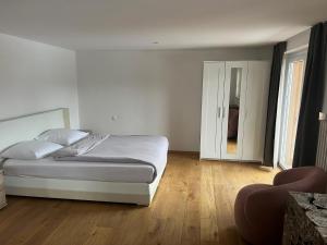 una camera con letto bianco e pavimento in legno di Romantica Grächen a Grächen