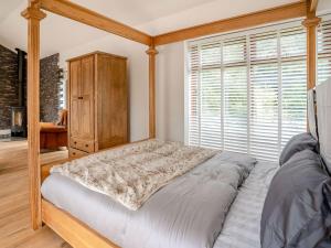 a bedroom with a bed and a large window at Ty Afon Arch - Uk38515 in Garnant