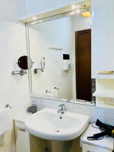 ein Badezimmer mit einem Waschbecken und einem großen Spiegel in der Unterkunft Central Apartment Private Parking Terrace & AC in Desenzano del Garda