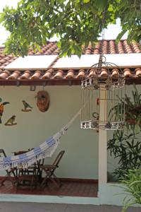 a bird cage hanging from the side of a house at Pousada Tia Nena in Olímpia