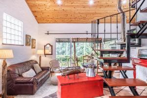 a living room with a couch and a spiral staircase at Ivy Cottage by Madeira Sun Travel in Faial