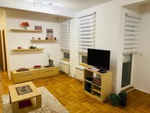 a living room with a flat screen tv on a stand at Jolly Apartment - Belgrade in Belgrade
