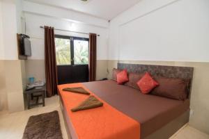 a bedroom with a large bed with red pillows at GRG Traveller in Panaji