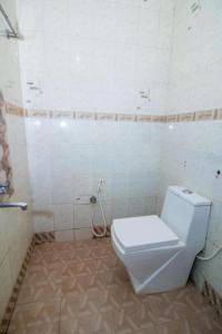 a bathroom with a white toilet and a shower at GRG Traveller in Panaji