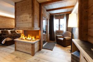 ein Wohnzimmer mit einem Kamin in einer Blockhütte in der Unterkunft Sci Sport rooms & suites in Bormio