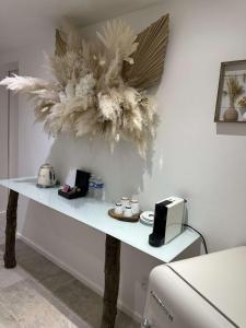 une table blanche avec une composition florale sur le mur dans l'établissement Appartement jacuzzi privé, à Avignon 2 autres photos