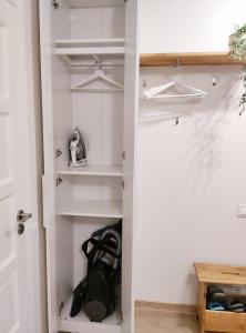 a closet with white shelves and a door at City center apartment in Klaipėda