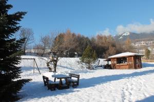 a picnic table in the snow next to a cabin at CASA PARADISO - Vista valle in Cavalese