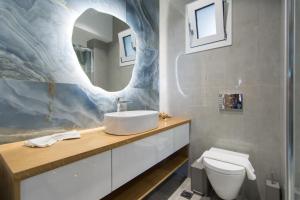 a bathroom with a sink and a toilet and a mirror at Casa di Prios brand new renovated Villa in Gouves in Gouves