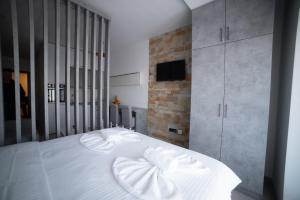 uma cama branca com duas almofadas num quarto em NLux 10 Apartment em Kopaonik