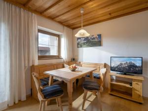 a dining room with a table and a television at Kröpflhof in Sankt Johann in Tirol
