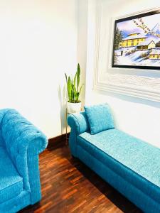 a blue couch and a chair in a living room at Newa service apartment in Pātan