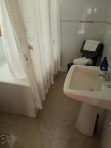 ein Badezimmer mit einem Waschbecken, einem WC und einer Badewanne in der Unterkunft Omi Kika B&B in Villarrica