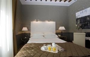 Un dormitorio con una cama y una bandeja con bebidas. en Duca d'Alba Hotel - Chateaux & Hotels Collection en Roma