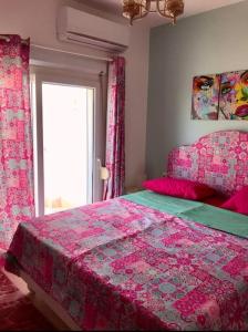 a bedroom with a pink bed and a window at Bright Get Away Condo in Sharm El Sheikh