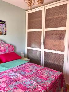 a bedroom with a bed with a pink bedspread at Bright Get Away Condo in Sharm El Sheikh