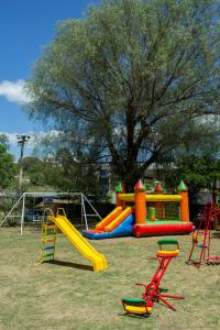 un parque infantil con tobogán y estructura de juegos en Capri Hotel y Cabañas by CPH en Villa Carlos Paz