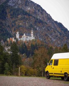 una furgoneta amarilla estacionada frente a un castillo en una montaña en Dreamer en Munster