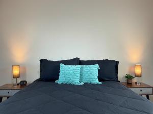 1 cama con 2 almohadas azules y 2 lámparas en Cozy Homeharrison Ranchhr1, en Visalia