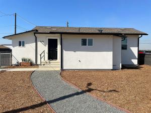 una casa blanca con una entrada delante de ella en Cozy Homeharrison Ranchhr1, en Visalia