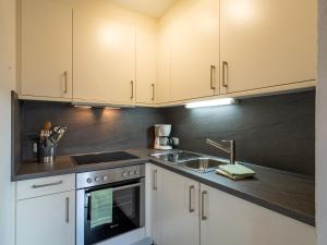 a kitchen with white cabinets and a sink at Kröpflhof in Sankt Johann in Tirol