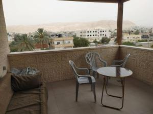balcón con mesa, sillas y sofá en Newly Built 3 Bedroom Condo in Jericho City Center en Jericho