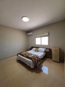 1 dormitorio con 2 camas y ventana en Newly Built 3 Bedroom Condo in Jericho City Center en Jericho