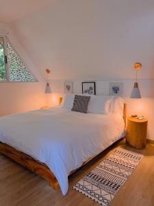 a bedroom with a large white bed with a rug at Amalú Monteverde in Monteverde Costa Rica