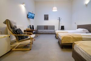 a room with several beds and a chair and a couch at Jundula in Šakiai +131 photos