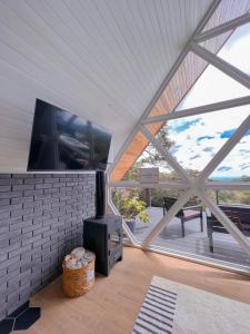 ein Wohnzimmer mit einem großen Fenster und einem Flachbild-TV in der Unterkunft Amalú Monteverde in Monteverde Costa Rica