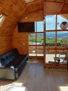 a living room with a couch and a large window at Glamping VILLA - Nueva en Paipa in Paipa