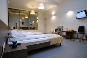 a large bedroom with two beds and a television at Jundula in Šakiai