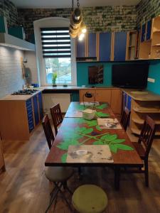 a kitchen with a wooden table with chairs and a kitchen with blue cabinets at Pokoje pracownicze Witkowska in Gniezno