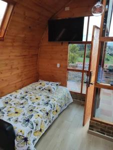 a bedroom with a bed and a flat screen tv at Glamping VILLA - Nueva en Paipa in Paipa